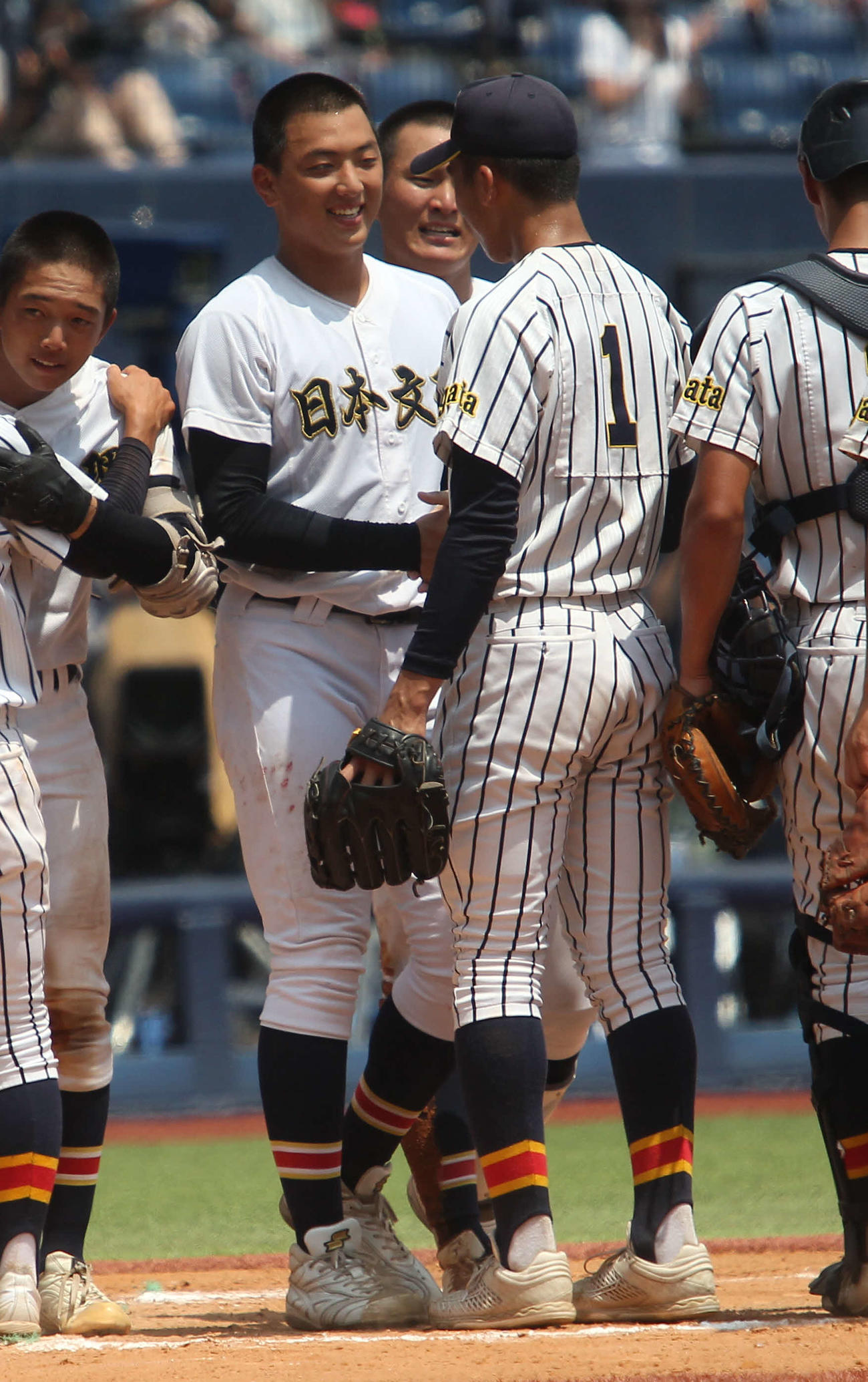 健闘をたたえ合い、握手する日本文理・田中（左）と帝京長岡・茨木秀