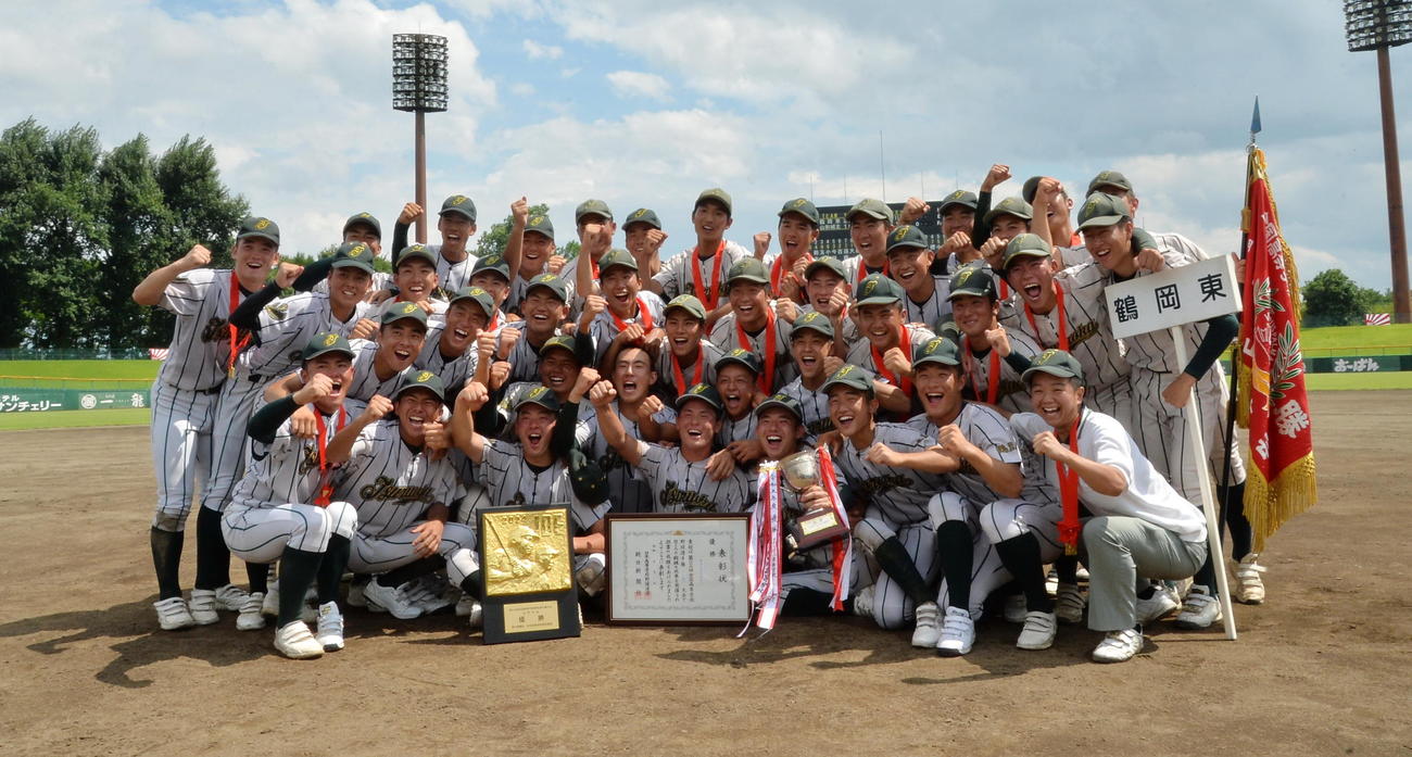 鶴岡東対東北文教大山形城北　2年ぶり8度目の優勝を果たし、力強いガッツポーズで記念撮影する鶴岡東ナイン（撮影・濱本神威）