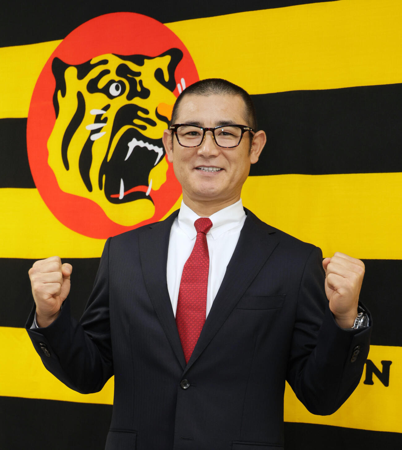 阪神の1軍打撃コーチに就任した坪井智哉氏は、「現役時代はやった事ないんですよ」と言いながらガッツポーズを見せる（撮影・宮崎幸一）