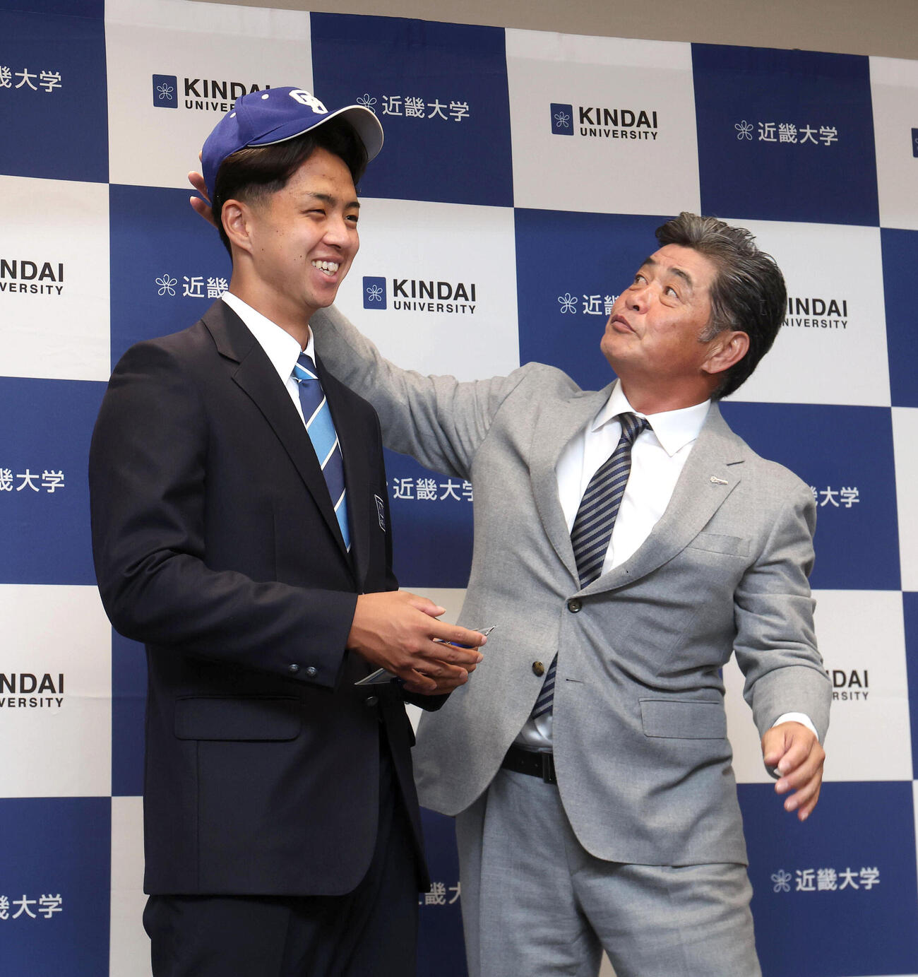 中日ドラフト1位の近大・宮原廉（左）に帽子を被せる工藤公康監督（撮影・白石智彦）
