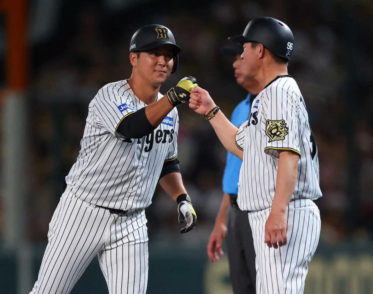 【画像・写真】＜神・D＞2回、井坪（左）は左前打を放ち、筒井コーチとタッチを交わす（撮影・後藤　大輝）