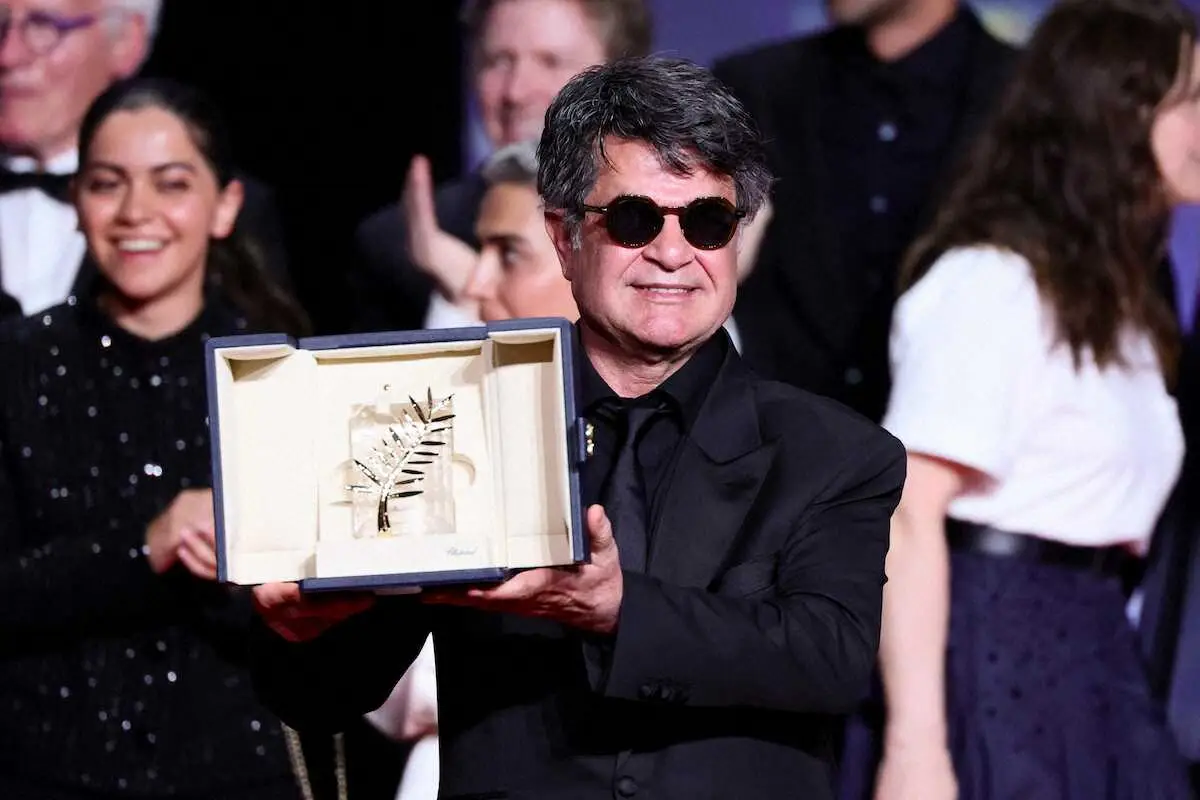 【画像・写真】　第78回カンヌ国際映画祭の授賞式で、最高賞パルムドールのトロフィーを掲げ、笑顔を見せるジャファル・パナヒ監督＝24日、フランス・カンヌ（ゲッティ＝共同）